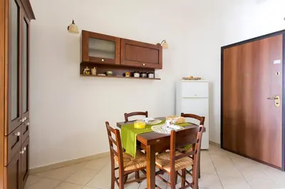 a kitchen with a table with chairs and a microwave at Oasi Centrale in Palermo
