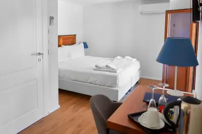a bedroom with a bed and a desk with a lamp at Sopra Le Mura in Castellammare del Golfo