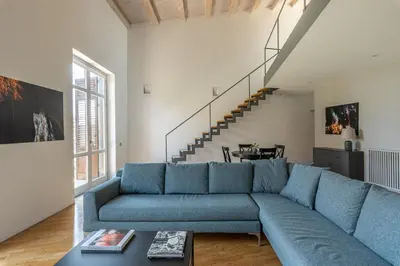 a living room with a blue couch and a staircase at Cala Loft by Wonderful Italy in Palermo
