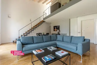 a living room with a blue couch and a staircase at Cala Loft by Wonderful Italy in Palermo