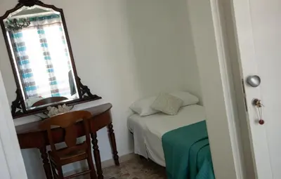 a small bedroom with a bed and a mirror at Orlando Bayview in Balestrate