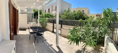 a patio with a table and chairs on a balcony at Appartamento Il Pomodoro in San Vito lo Capo