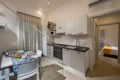 a small kitchen with a table and a kitchen gmaxwell gmaxwell gmaxwell gmaxwell gmaxwell at Le Perle del Golfo in Castellammare del Golfo