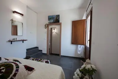 a bedroom with a bed and a door with a window at Le Perle del Golfo in Castellammare del Golfo