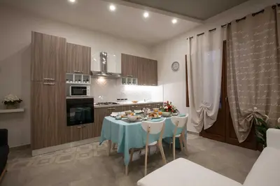 a kitchen with a table with a blue table cloth at Le Perle del Golfo in Castellammare del Golfo