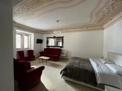 a bedroom with a bed and a couch and chairs at Lercarappart in Lercara Friddi