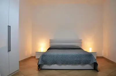a bedroom with a bed with two candles on two tables at Lercarappart in Lercara Friddi