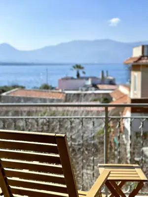 a wooden bench sitting on a balcony overlooking the ocean at Garden House Alla Torre in Isola delle Femmine