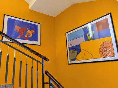 two framed pictures on a wall next to a staircase at Garden House Alla Torre in Isola delle Femmine