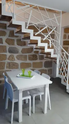 a white table and chairs in front of a brick wall at Maresol in Trappeto