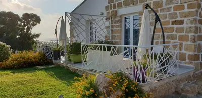 a stone house with a balcony with plants on it at Maresol in Trappeto