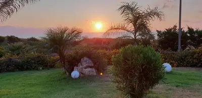 a sunset in a yard with a lawn with plants at Maresol in Trappeto