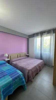 a bedroom with a bed and a purple wall at Maresol in Trappeto
