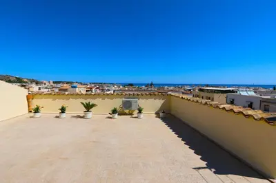 a balcony with potted plants and a view of a city at B&B Orchidea in San Vito lo Capo