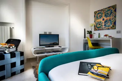a living room with a blue couch and a tv at Trikeles in Palermo