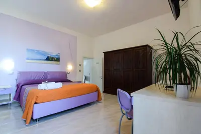 a bedroom with a bed and a potted plant at B&B Alighieri 21 in San Vito lo Capo