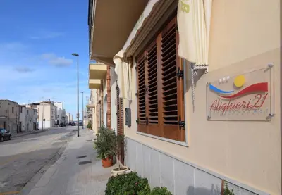 a building with a sign on the side of a street at B&B Alighieri 21 in San Vito lo Capo