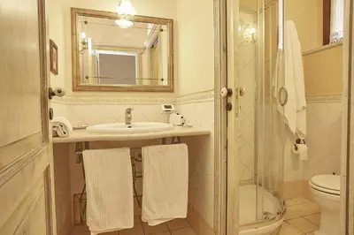 a bathroom with a sink and a toilet and a mirror at Locanda del Gagini in Palermo