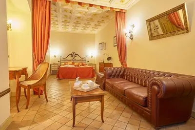 a living room with a leather couch and a bed at Locanda del Gagini in Palermo