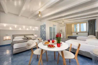 a bedroom with a bed and a table and chairs at Albert Rooms & Breakfast in San Vito lo Capo