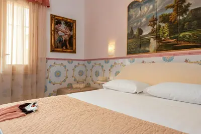 a bedroom with a bed with a cat sitting on it at Albert Rooms & Breakfast in San Vito lo Capo