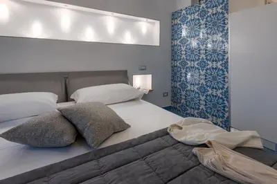 a bedroom with two beds and a blue wall at Albert Rooms & Breakfast in San Vito lo Capo