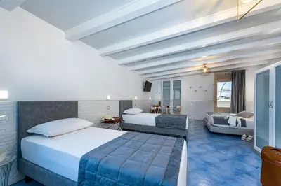 a hotel room with two beds and a couch at Albert Rooms & Breakfast in San Vito lo Capo