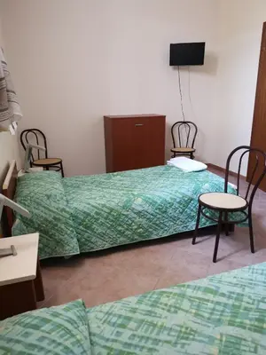 a hotel room with two beds and a tv at Albergo Ristorante Pizzeria Del Viale in Palazzo Adriano