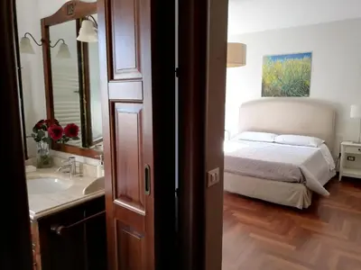 a bedroom with a bed and a sink and a mirror at B & B Villa Flora in Mondello