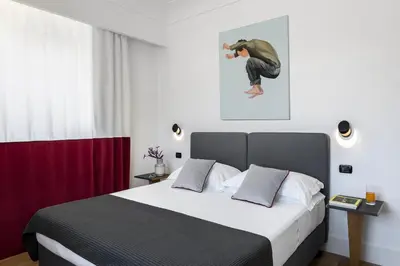 a bedroom with a bed with a person jumping on the wall at Hotel Plaza Opéra in Palermo