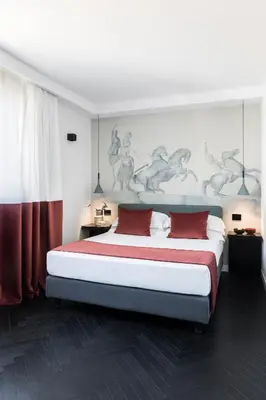 a bedroom with a large bed with red pillows at Hotel Plaza Opéra in Palermo