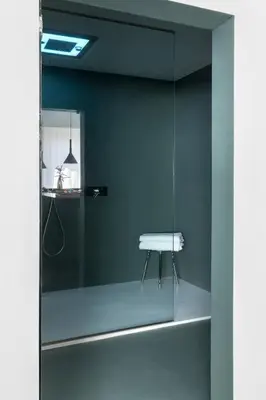 a glass shower with a white stool in a bathroom at Hotel Plaza Opéra in Palermo