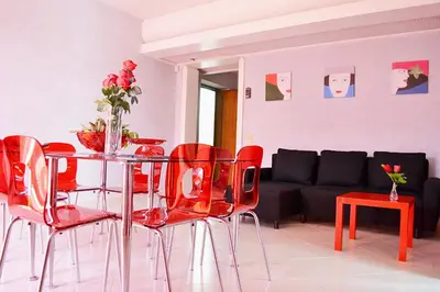 a living room with a table and red chairs at Appartamento da Andrea in Alcamo