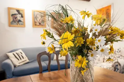 a vase filled with yellow and white flowers on a table at Casetta Nostra in Palermo