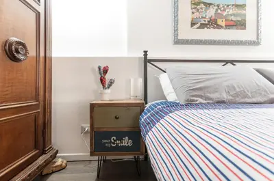 a bedroom with a bed and a nightstand next to a bed at Casetta Nostra in Palermo