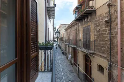 a narrow alley with a lamp on a balcony at Casetta Nostra in Palermo