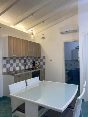 a kitchen with a white table and chairs at Le Quattro Perle in Terrasini