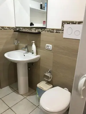 a bathroom with a white sink and a toilet at Le Quattro Perle in Terrasini