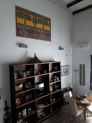 a living room with a large wooden book shelf at Speciale Apartment in Palermo