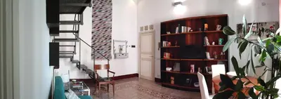 a living room with a staircase and a book shelf at Speciale Apartment in Palermo