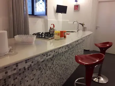 a kitchen with a counter with a stove and stools at A un passo dal Massimo in Palermo