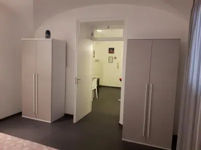 a room with white cabinets and a room with a table at A un passo dal Massimo in Palermo