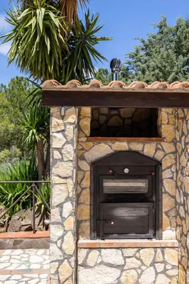a brick oven in a stone building with a roof at Villa Cocos in Casteldaccia