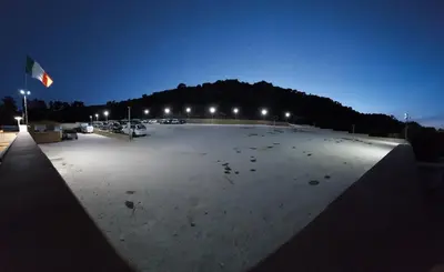 a large parking lot at night with a mountain at Catalina in San Vito lo Capo