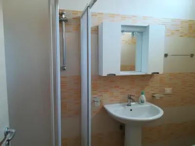 a bathroom with a sink and a shower with a mirror at Vicino al mare e lontano dai rumori in Alcamo Marina