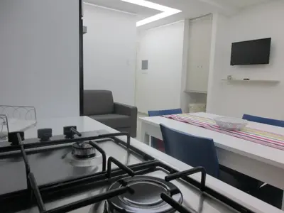 a kitchen with a stove and a table with chairs at Le Dimore di Enea in Castellammare del Golfo