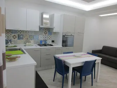 a kitchen and dining room with a table and chairs at Le Dimore di Enea in Castellammare del Golfo