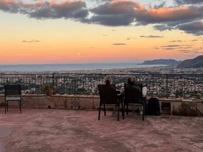 a couple sitting at a table watching the sunset at Palazzo Q-tò in Monreale