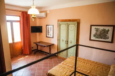 a bedroom with a bed and a desk in a room at Palazzo Q-tò in Monreale
