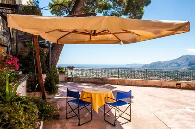 a table and two chairs under a large umbrella at Palazzo Q-tò in Monreale
